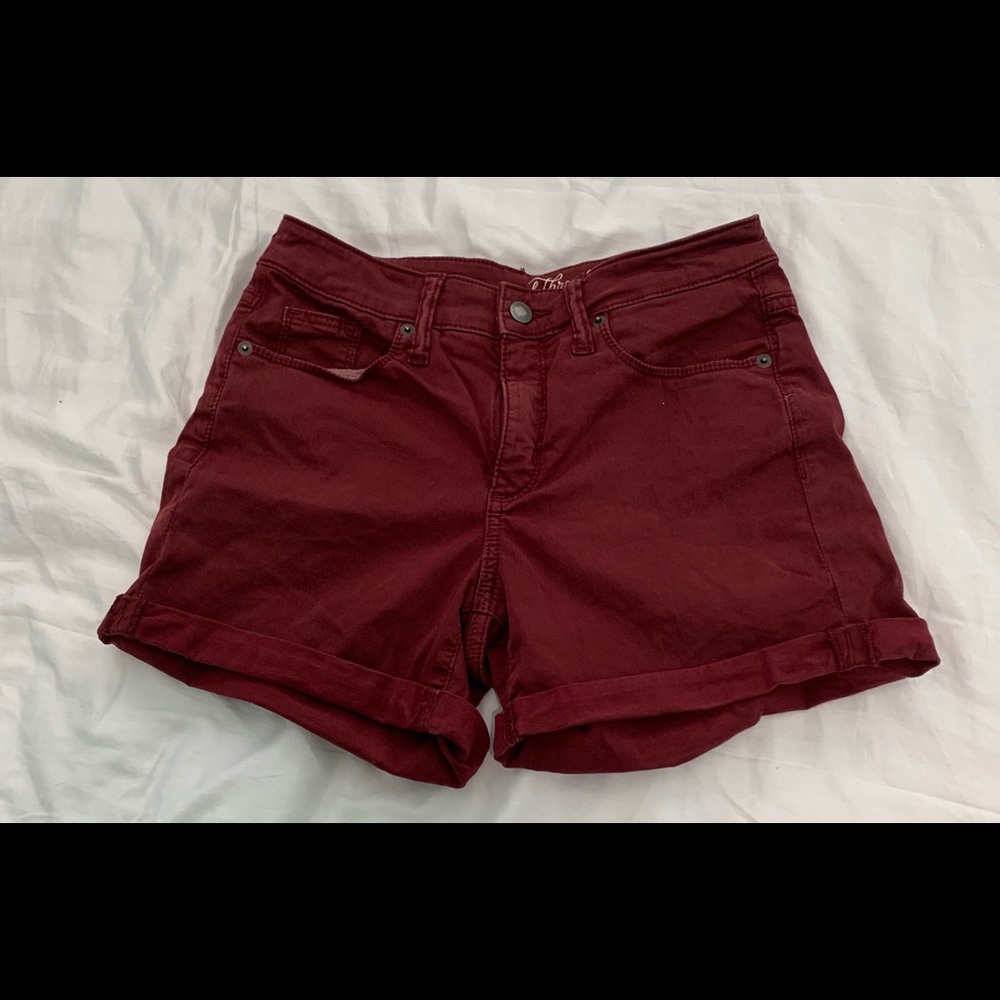 Maroon, mid-length, cuffed shorts.